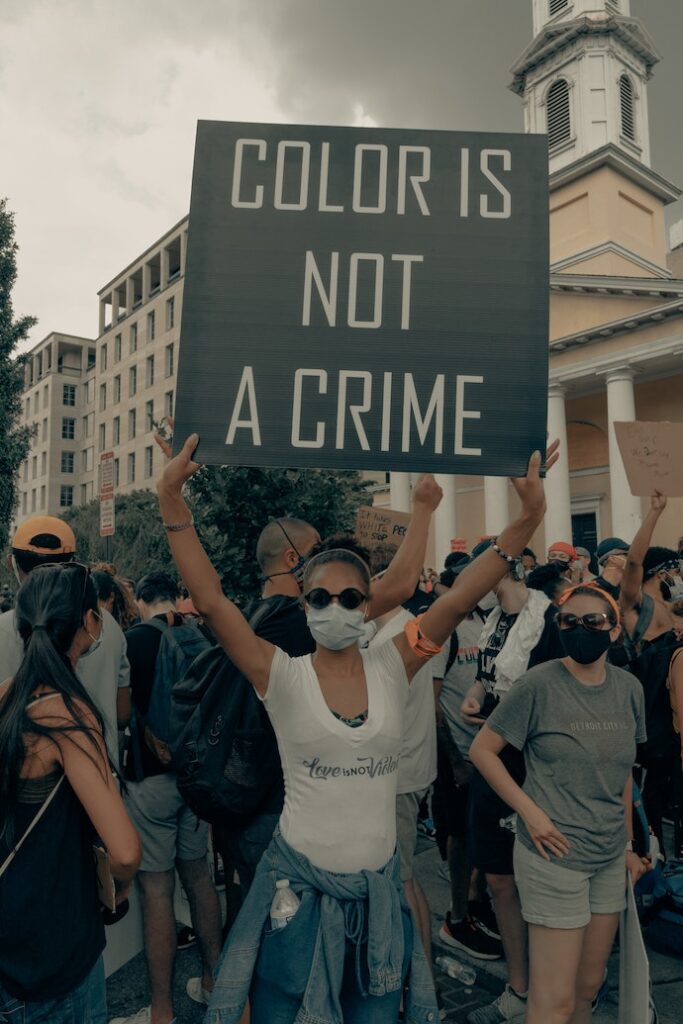 Woman holding a sign "Color is not a crime"