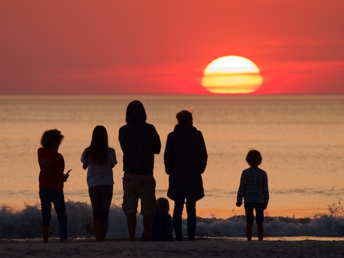 Family is watching the sunset over the ocean