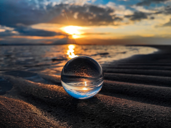 Glass ball on the beach during sunset