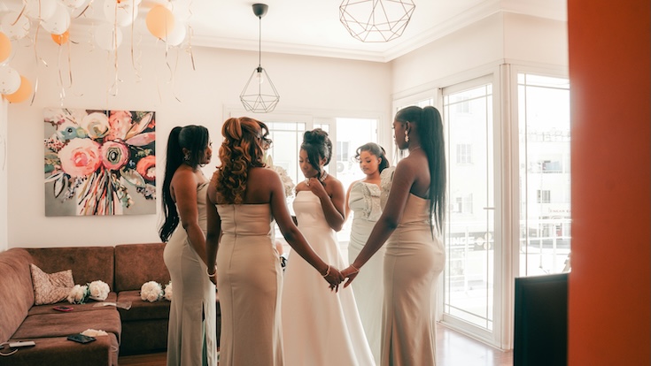 A bride and her bridesmades standing in a room